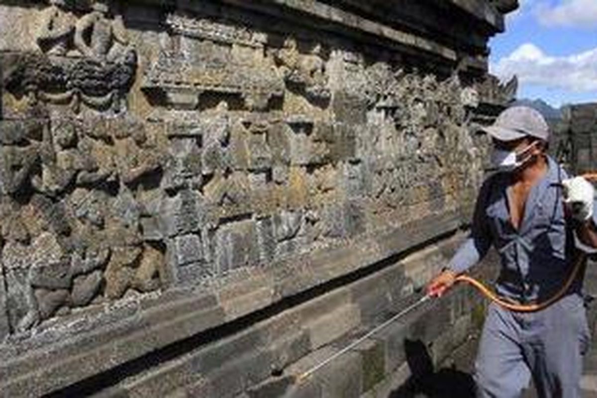 Wadirman, menyemprotkan cairan herbisida ke relief Candi Borobudur di Magelang, Jawa Tengah, Selasa (25/5/2010). Ia bertugas membersihkan candi dari serangan lumut yang dapat merusak batu candi. Pembersihan candi dilakukan secara berkala untuk menjaga kekuatan batu. 