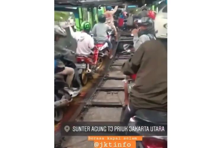 Tangkapan layar dari sebuah video viral mengenai beberapa pemotor yang menumpangi truk trailer saat banjir menggenangi Jakarta pada Sabtu (8/2/2020).