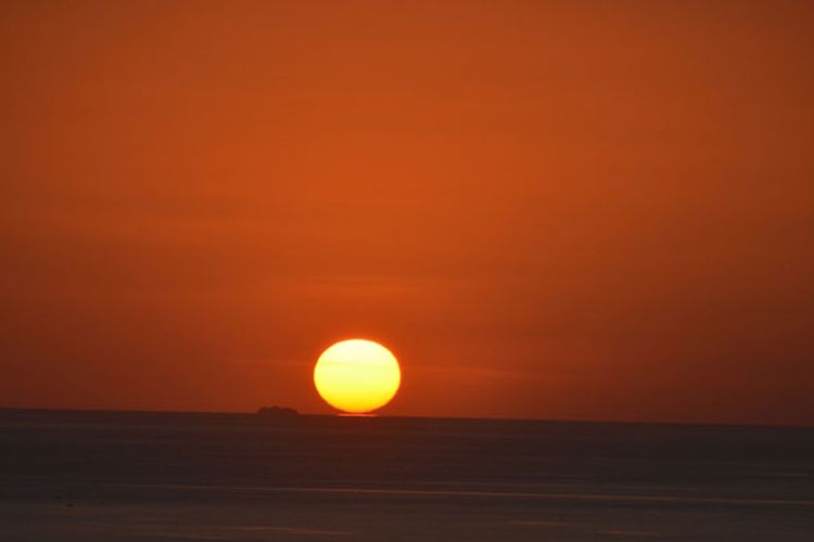 Matahari menyentuh air laut di ujung barat Pulau Flores saat terbenam, Senin (28/8/2017). Ini merupakan salah satu keunikan saat matahari terbenam di Manggarai Barat, Nusa Tenggara Timur.