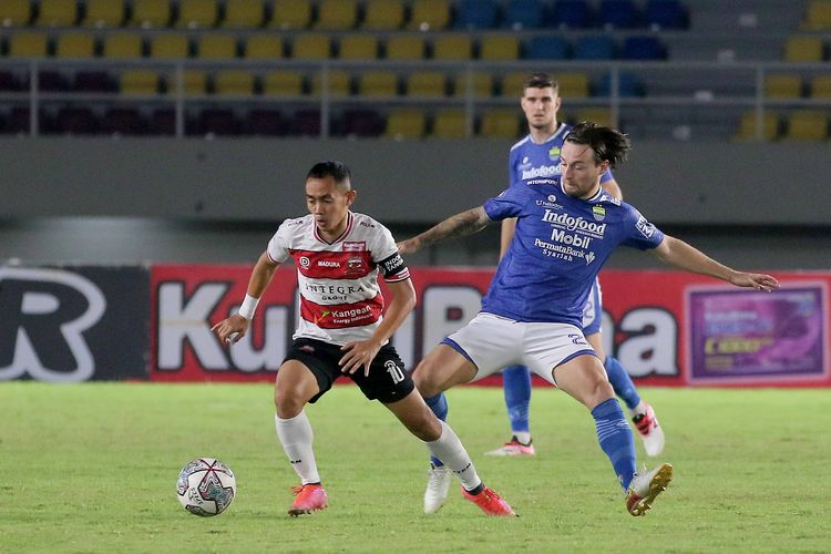 Kapten Madura United Slamet Nurcahyo dijara ketat pemain Persib Bandung Marc Klok pada pertandingan pekan 15 Liga 1 2021-2022 yang berakhir dengan skor 0-1 di Stadion Manahan Solo, Sabtu (4/12/2021) malam.