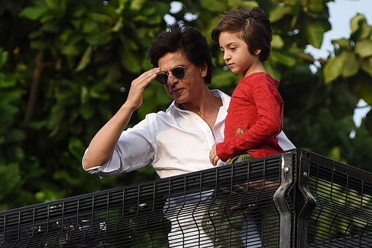 Aktor Bollywood Shah Rukh Khan dan putra bungsunya, Abram Khan, menyambut ucapan selamat Idul Fitri dari penggemarnya yang berkumpul di depan rumahnya di Mumbai, India, Rabu (5/6/2019). 