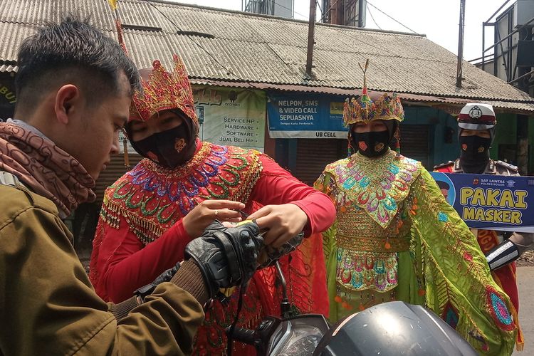 Petugas Kepolisian memberi masker kepada pengendara sepeda motor di Jalan Raya Bogor, Cibinong, Kabupaten Bogor, Jawa Barat, Selasa (15/9/2020)