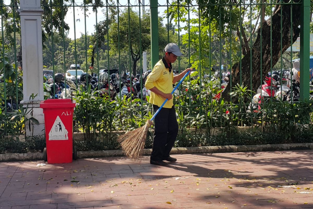 Ali Santoso (48) membersihkan sampah-sampah yang mengotori pedestrian di luar kawasan Monumen Nasional (Monas) di Jalan Medan Merdeka Selatan, Jakarta Pusat, Rabu (28/6/2017). Ia tidak libur pada hari Lebaran 2017.