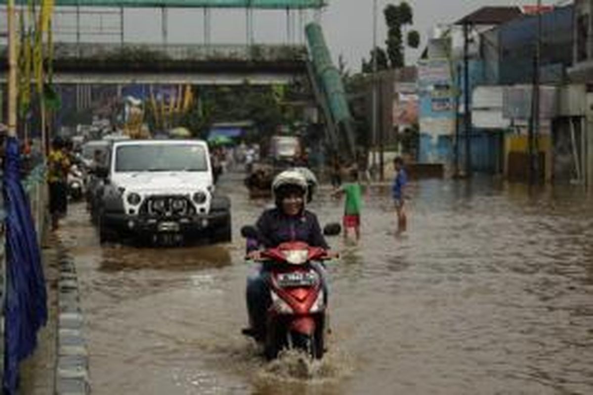 Kendaraan melintas di tengah banjir di jalan KH Abdullah Syafei, Jakarta, Senin (20/1/2014). Banjir diakibatkan oleh meluapnya debit air Sungai Ciliwung karena hujan yang melanda Jakarta dan sekitarnya.  