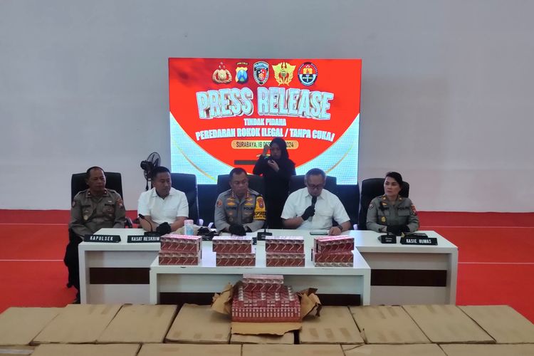 Polisi di depan rokok ilegal yang disita, Mapolrestabes Surabaya, Senin (16/12/2024).