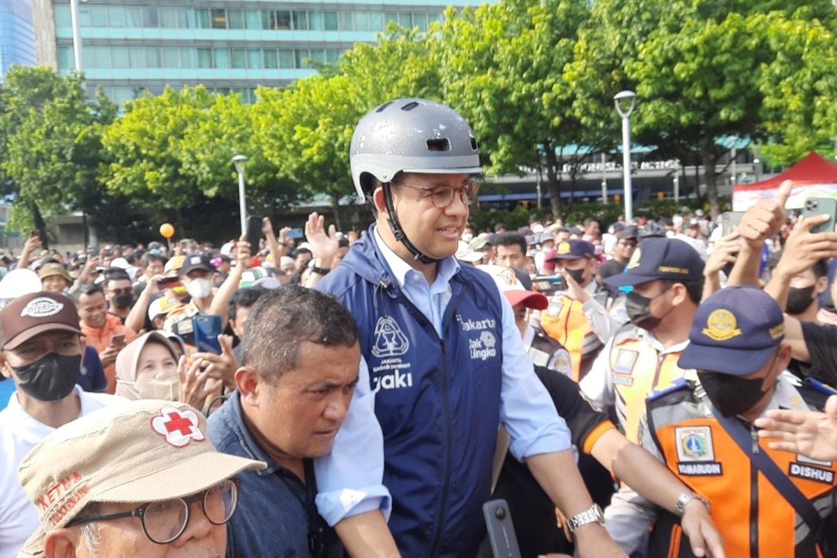 Gubernur DKI Anies Baswedan menyapa peserta car free day (CFD) di Bundaran Hotel Indonesia (HI), Jakarta Pusat, Minggu (16/10/2022) pagi. Ia tiba di Bundaran HI sekitar pukul 07.57 WIB. Dengan menaiki sepeda, Anies berbaur dengan masyarakat.