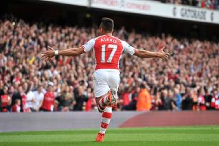 Penyerang Arsenal, Alexis Sanchez, merayakan golnya ke gawang Hull City, pada laga Premier League, di Emirates Stadium, Sabtu (18/10/2014).