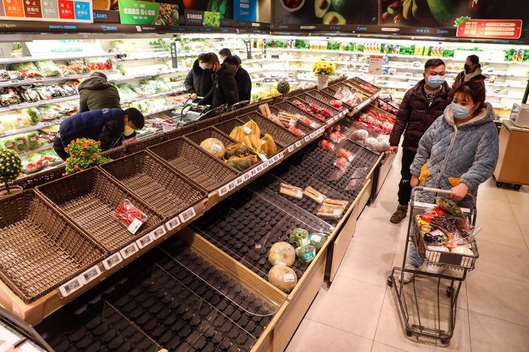 epaselect epa08163556 A masked shopper looks at the empty baskets on a counter in a supermarket in Wuhan in central Chinas Hubei province 25 January 2020. The city struck by the 2019-nCoV virus will ban private traffic starting on Sunday, prompting citizens to a shopping spree of necessities and groceries.  EPA-EFE/YUAN ZHENG CHINA OUT