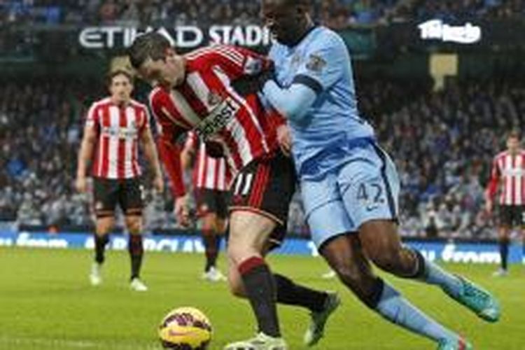 Gelandang Manchester City, Yaya Toure (kanan), berebut bola dengan pemain Sunderland, Adam Johnson, dalam laga Premier League di Etihad, Manchester, Kamis (1/1/2015).