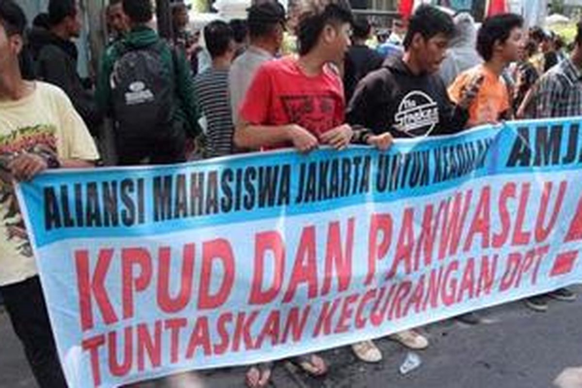 Massa menggelar spanduk tuntutan penuntasan masalah DPT saat berunjukrasa di depan KPUD DKI Jakarta, Jakarta Pusat, Kamis (28/6/2012). Selain itu mereka juga menuntut agar aparat pemerintahan yang terlibat dalam kisruh itu dipidanakan. 