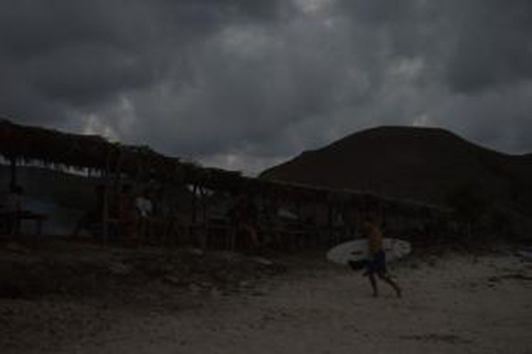 Seorang wisatawan mancanegara berjalan di pasir usai berselancar di Pantai Seger, Desa Kuta, Kecamatan Pujut, Lombok Tengah, Nusa Tenggara Barat, Jumat (20/11/2015) sore. Pantai Seger merupakan tempat berselancar bagi wisatawan yang telah memiliki keahlian.