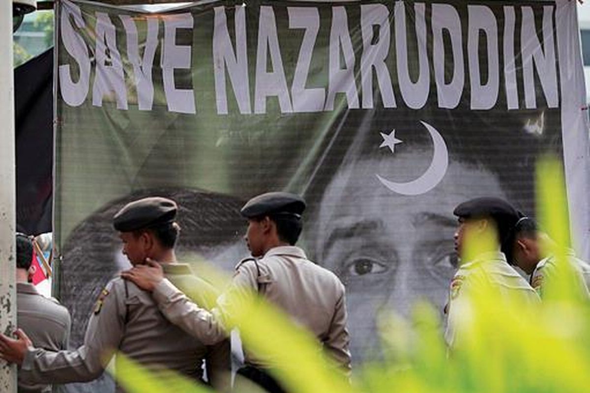 Polisi menjaga unjuk rasa yang dilakukan massa dari Front Pembela Nazaruddin di Komisi Pemberantasan Korupsi (KPK), Jakarta, Selasa (9/8). Mereka  memberi dukungan kepada Nazaruddin untuk membongkar skandal korupsi di Partai Demokrat dan meminta KPK melindungi buronan yang paling dicari tersebut setibanya di Indonesia.