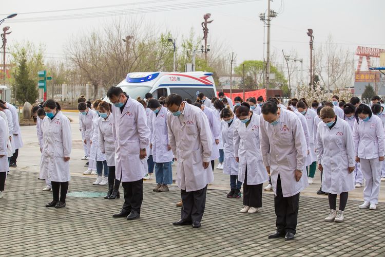 Dokter dan perawat di Rumah Sakit Rakyat Kuga Nomor 2 Chuanranbing membungkukan badan sebagai bentuk penghormatan bagi korban meninggal di Region Otonomi Xinjiang, China, pada 4 April 2020.