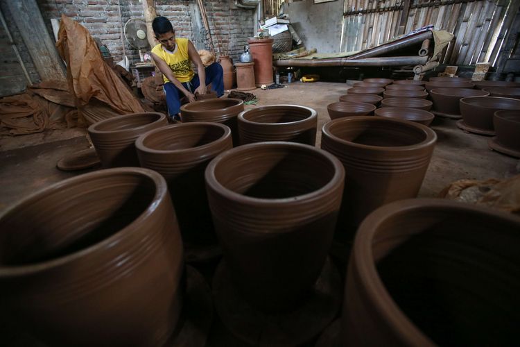 Perajin menyelesaikan pembuatan gerabah di Kasongan, Bantul, DIY, Kamis (22/10/2020). Di masa pandemi Covid-19 permintaan akan gerabah terutama pot bunga mengalami peningkatan.