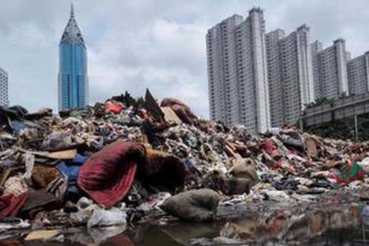 Sampah menumpuk di tepi Jalan KH Mas Mansyur di depan Tempat Pemakaman Umum Karet Bivak, Jakarta, Selasa (22/1/2013). Banjir selain membawa sampah juga menyebabkan pengangkutan sampah permukiman terhenti karena jalanan lumpuh. KOMPAS/IWAN SETIYAWAN