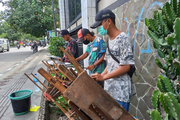 Pengamen angklung jalanan di Semarang sedang memainkan aksinya