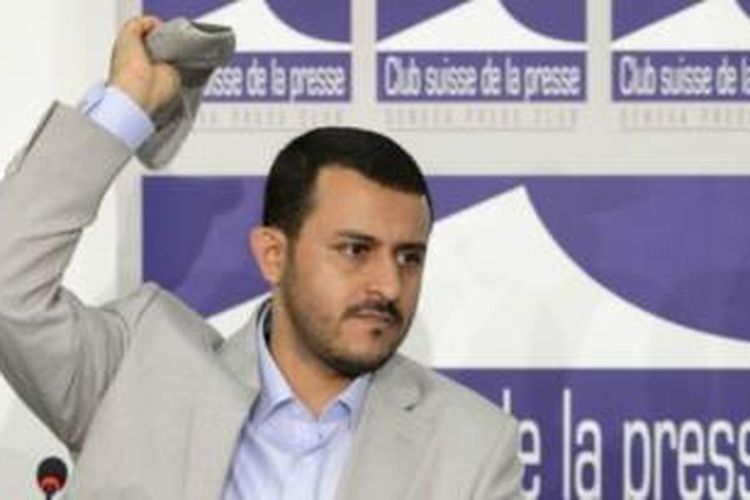 Pimpinan delegasi Houthi dalam perundingan di Swiss, Hamza al-Houthi melemparkan balik sebuah sepatu yang sebelumnya dilemparkan ke arah dirinya dalam jumpa pers di Geneva, Jumat (19/6/2015).