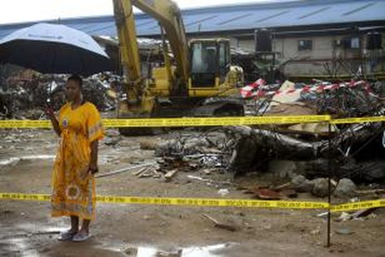 Lindiwe Ndwandwe (33), berdiri di sisa bangunan tiga lantai gereja yang runtuh dan sempat menguburnya selama 5 hari. Bangunan tersebut merupakan gereja sinagog segala bangsa (SCOAN), yang runtuh pada 16 September 2014. 