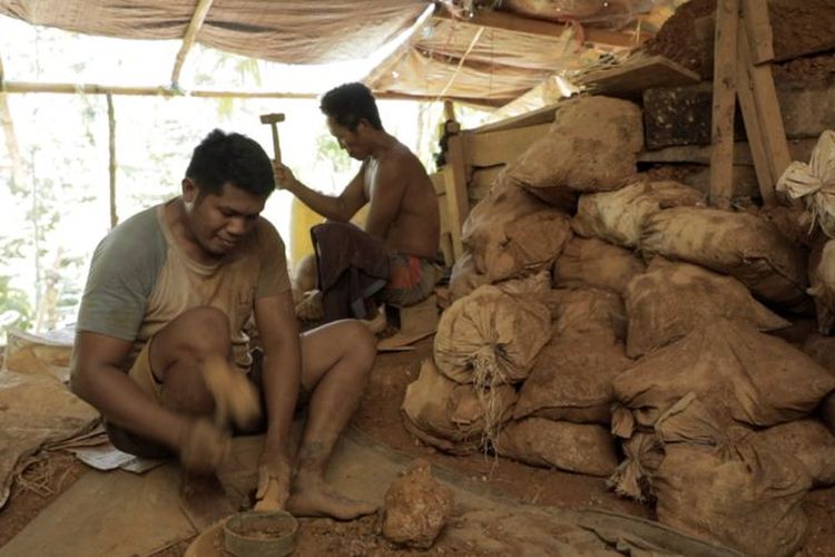 Seorang warga memecahkan bebatuan di pertambangan emas tanpa izin di Bowone, Kepulauan Sangihe.