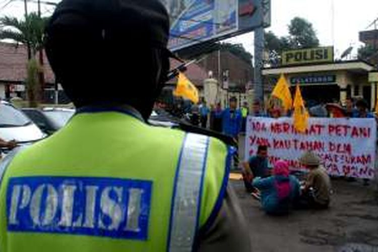 Petugas kepolisian melihat aksi teaterikal mahasiswa tergabung PMII saat demonstrasi di Polres Sukabumi Kota, Senin (21/11/2016). 