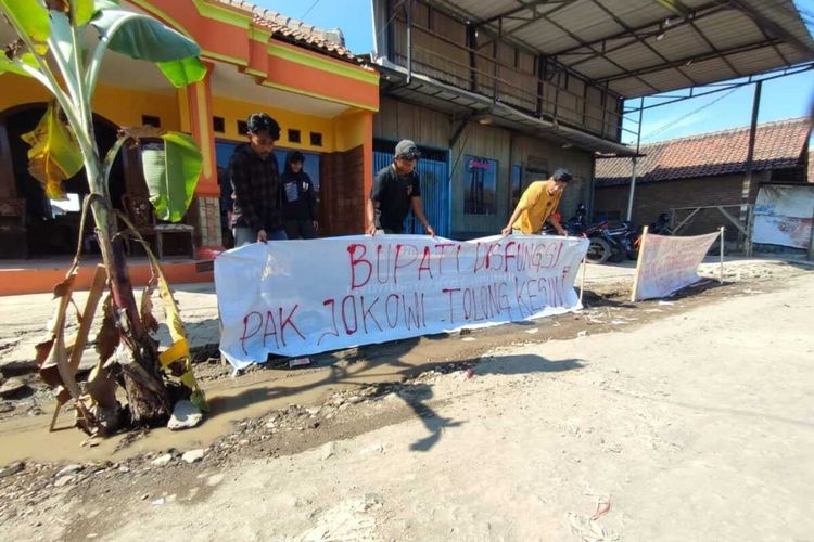 Sejumlah warga memasang spanduk dan menanam pohon pisang di jalan rusak Desa Kaliwulu dan Desa Cangkring Kecamatan Plered Kabupaten Cirebon, Rabu (10/5/2023).