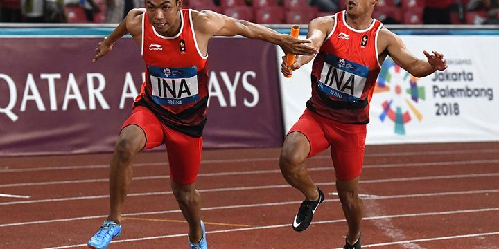 Pelari Indonesia Fadlin (kanan) menyerahkan tongkat kepada Lalu Muhammad Zohri pada babak final Lari Estafet 4x100m Putra Asian Games ke-18 Tahun 2018 di Stadion Utama Gelora Bung Karno Senayan, Jakarta, Kamis (30/8/2018). Lalu Muhammad Zohri, Fadlin, Eko Rimbawan dan Bayu Kertanegara mencatatkan waktu 38,77 detik sekaligus mempersembahkan medali pertama Indonesia dari nomor 4 x 100 meter sejak tahun 1966.