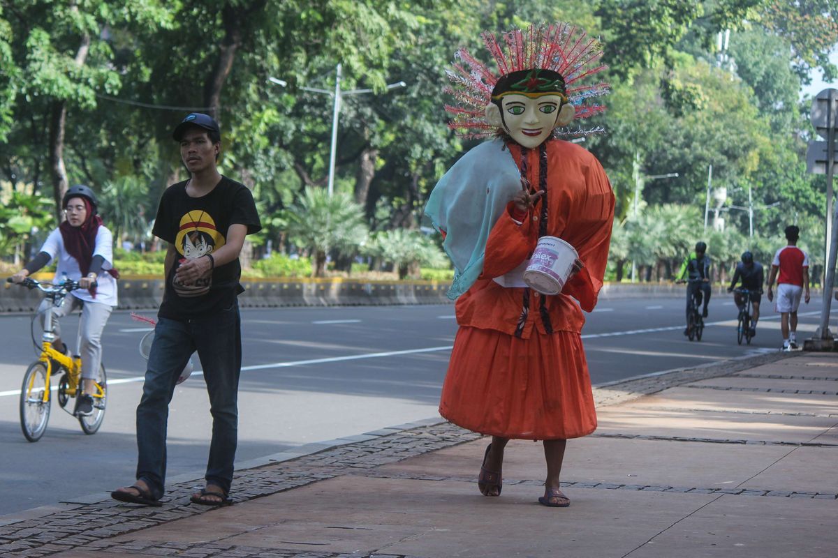 Para pengamen ondel-ondel di kawasan Monumen Nasional, Gambir, Jakarta Pusat, Minggu (9/2/2020). Pemprov DKI Jakarta akan merevisi Peraturan Daerah Nomor 4 Tahun 2015 tentang Pelestarian Kebudayaan Betawi yang di mana ondel-ondel merupakan salah satu kebudayaan khas Betawi.