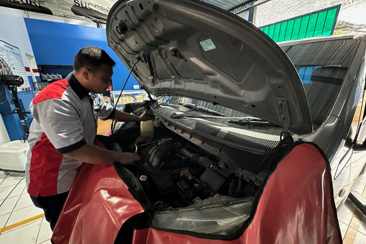 Seorang montir sedang memeriksa mobil pelanggannya di Bengkel Plat AD Auto Service, Mojolaban, Sukoharjo, Jawa Tengah pada Selasa (11/11/2024).