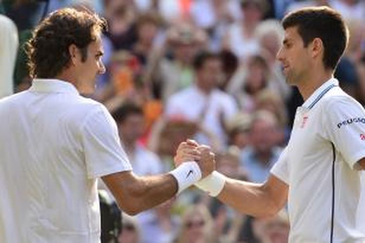 Petenis Serbia, Novak Djokovic (kanan), bersalaman dengan petenis Swiss, Roger Federer, setelah laga final Wimbledon di All England Tennis Club, London, Minggu (6/7/2014). Djokovic menang 6-7 (7), 6-4, 7-6 (4), 5-7, 6-4.
