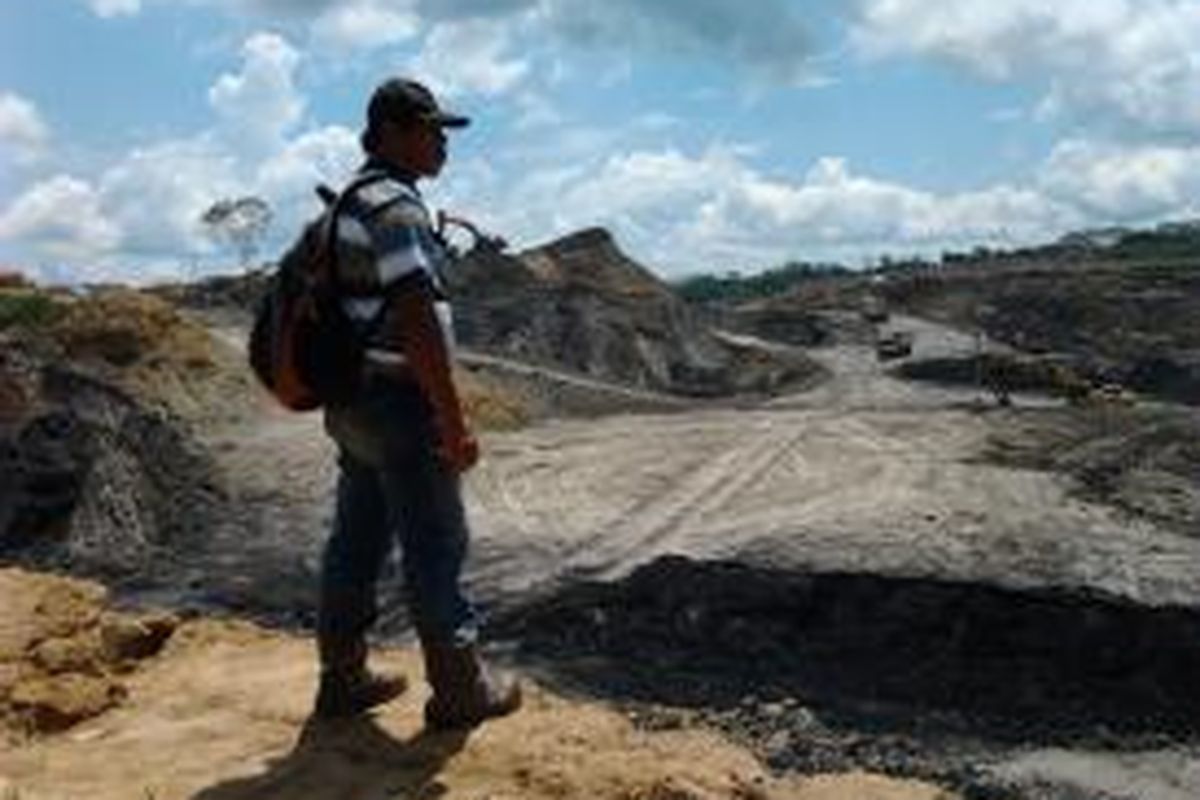 Aktivitas tambang batu bara KE. Seorang warga penjaga lahan mengawasi aktivitas KE dari jauh.