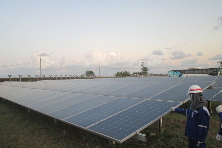 Pengunjung mengamati panel surya di pembangkit listrik tenaga surya (PLTS) Pertamina Refinery Unit (RU) IV Cilacap di area Rumah Sakit Pertamina Cilacap (RSCP) di Cilacap, Jawa Tengah, Selasa (28/6/2022).