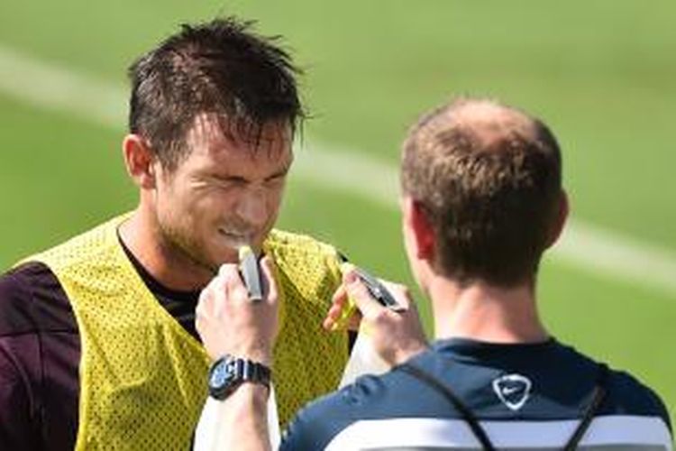 Salah satu staf tim nasional Inggris menyemprot wajah Frank Lampard dengan air di sela-sela latihan yang digelar di Urca, Rio de Janeiro, Senin (9/6/2014).  
