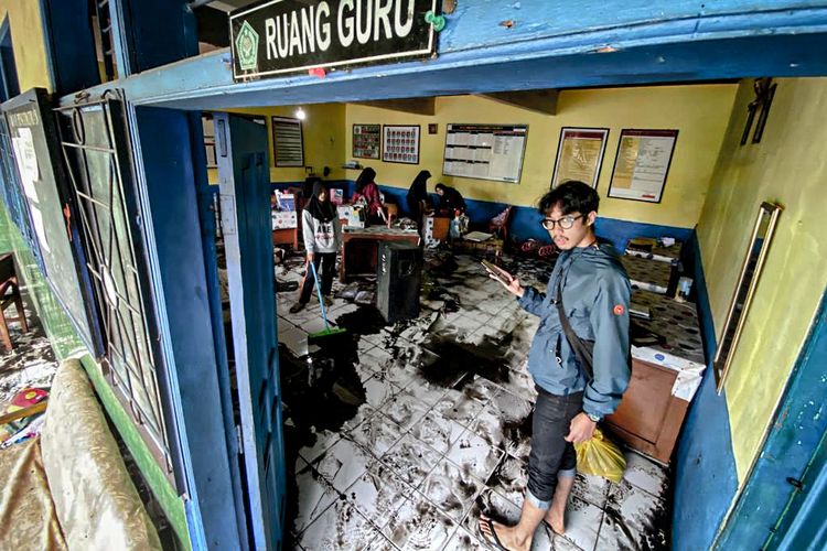 Sejumlah siswa MTs Darussalam, Kota Cimahi membersihkan lumpur sisa banjir yang merendam wilayah Kelurahan Melong, Kota Cimahi, Jawa Barat, Rabu (6/12/2023).