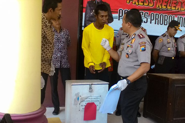 Ashari (berkaos kuning) menunjukkan cara mencuri kotak amal di masjid, di hadapan Kapolres Probolinggo AKBP Arman Asmara. Hasil uang curiannya digunakan untuk foya-foya.