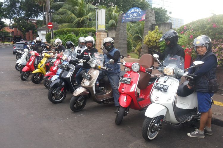 Para anggota komunitas vespa Kutu Community berkumpul di Taman Ayodya, Jakarta Selatan sebelum memulai kegiatan turing santai berkeliling Jakarta pada Senin (1/1/2018).