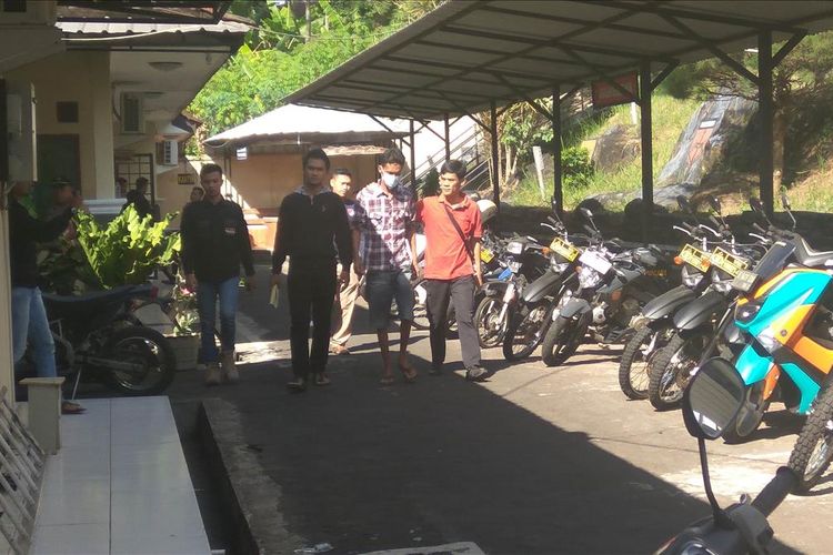 Penyidik Satreskrim Polres Ciamis menggelandang tersangka A (pakaian kotak-kotak) sebelum ekspos kasus perusakan rumah Menteri KKP, Susi Pudjiastuti di Mapolres Ciamis, Minggu (04/08/2019).