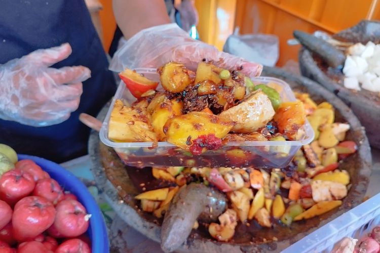 Sultan Yusuf Maulana (30) menunjukkan rujak buatannya di lapaknya yang berlokasi di depan  Seafood Muara Laut. Tepatnya di Jalan Kebon Kacang Raya No 12, Jakarta Pusat, Jumat (22/9/2023). (KOMPAS.com/XENA OLIVIA)