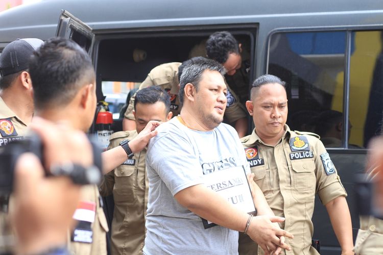 Yudi Tama Redianto (50) pelaku pembunuhan PNS Kementerian Pu Aprianita (50) saat sedang melakukan rekontruksi di kediaman korban. Pelaksanaan rekontruksi pun dijaga ketat oleh piham kepolisjan untuk menghindari amukan keluarga korban, Senin (2/12/2019).