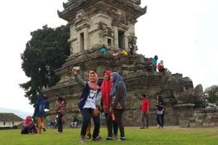 Sejumlah wisatawan saat berfoto selfie dengan latar Candi Jawi di Desa Candi Wates, Kecamatan Prigen, Kabupaten Pasuruan, Jawa Timur, Kamis (5/5/2016). Candi yang dibangun pada abad ke XIII ramai dikunjungi wisatawan pada hari pertama libur panjang.