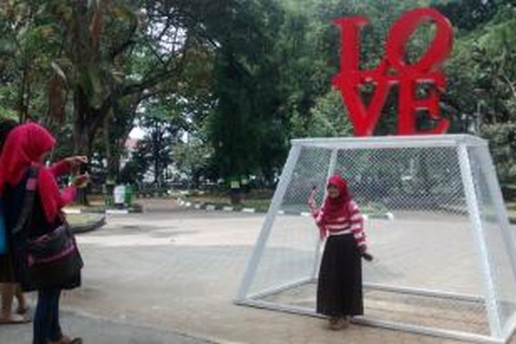 Warga masyarakat mengabadikan moment di depan bangunan Gembok Cinta yang ada di Balai Kota Bandung, Jalan Wastukancana, Kota Bandung, Jawa Barat.