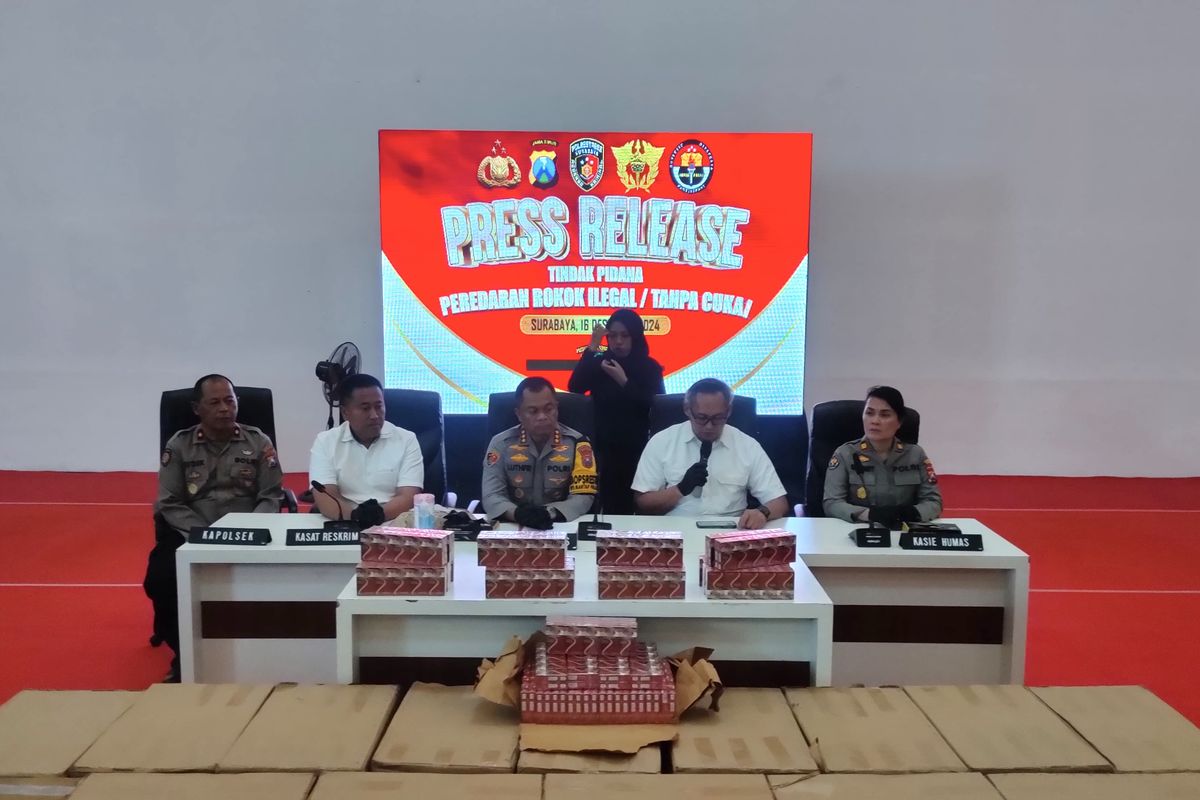 Polisi di depan rokok ilegal yang disita, Mapolrestabes Surabaya, Senin (16/12/2024).