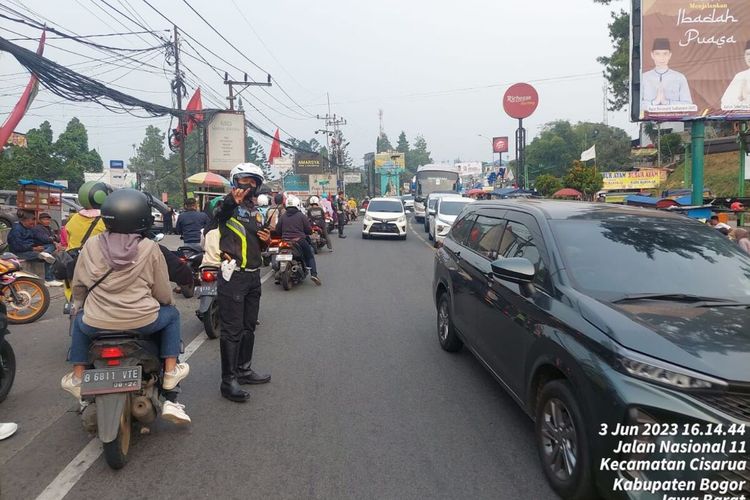 Polisi sedang mengatur arus lalu lintas kendaraan yang menuju ke kawasan wisata Puncak Bogor, Jawa Barat, Sabtu (3/6/2023).