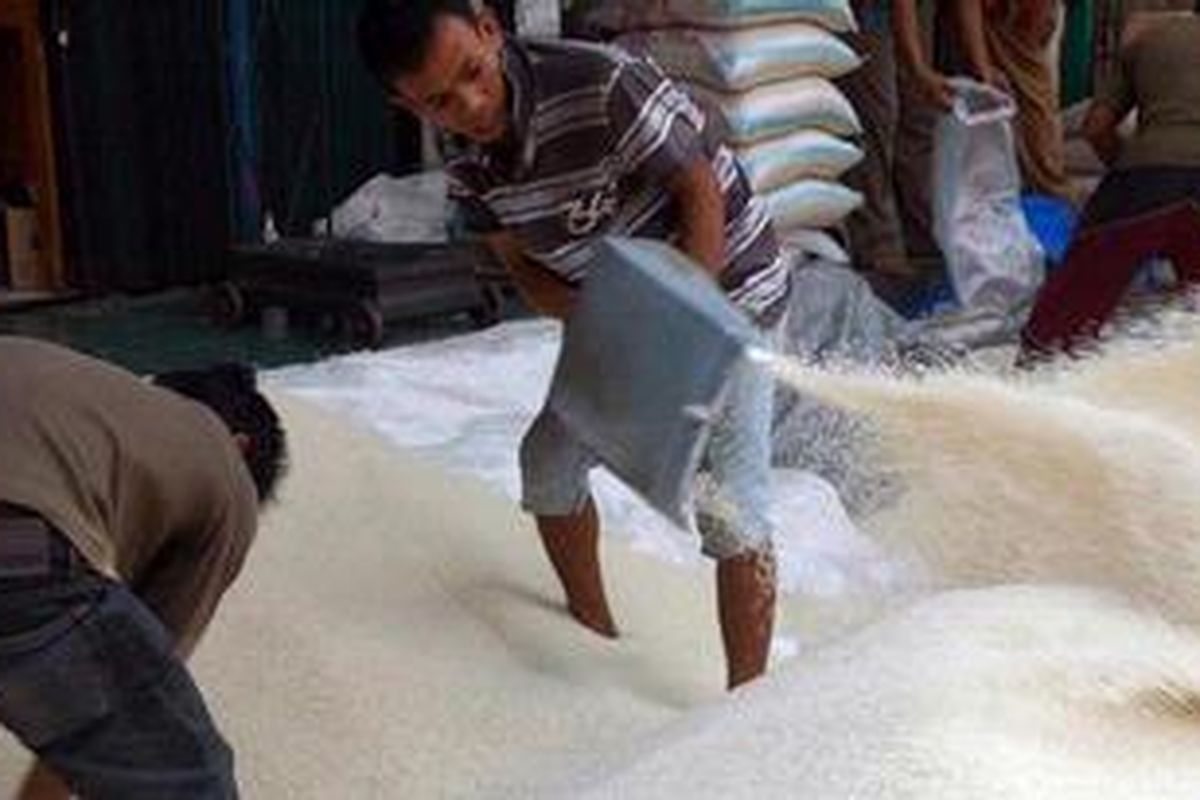 Pekerja mengumpulkan beras di Pasar Induk Cipinang, Jakarta Utara, Jumat (20/8/2010). Harga beras untuk jenis IR-64 kualitas II mencapai Rp 6,2 ribu per kilogram. Kenaikan ini bukan karena persediaan menipis namun karena konsumsi yang naik. Pemerintah memperkirakan stok beras cukup sampai akhir tahun dan kemungkinan akan mengalami surplus sebanyak lima juta ton. 