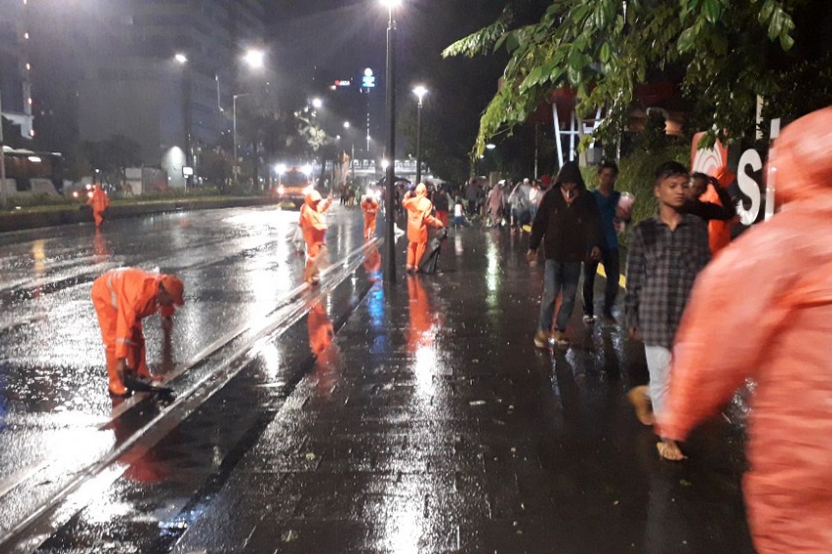 Pasukan Oranye mulai membersihkan sampah yang berserakan di Jalan MH Thamrin, Selasa (1/1/2019).