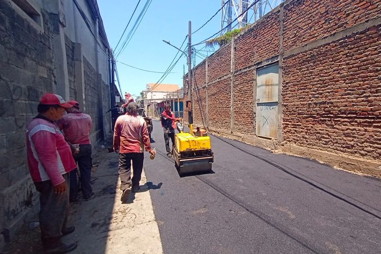 Tembok yang menutupi Jalan Tambak Wedi Baru, Kenjeran, menuju Jalan Dukuh Bulak Banteng, Surabaya, Jawa Timur, masih dalam proses pengaspalan, Sabtu (14/9/2024).