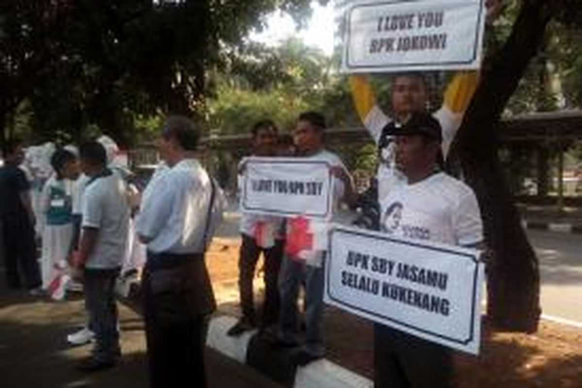 Masyarakat bersiap menyambut iring-iringan mobil Presiden Susilo Bambang Yudhoyono dan presiden terpilih, Joko Widodo yang akan melintas di Jalan Sudirman, Jakarta Pusat, Senin (20/10/2014)