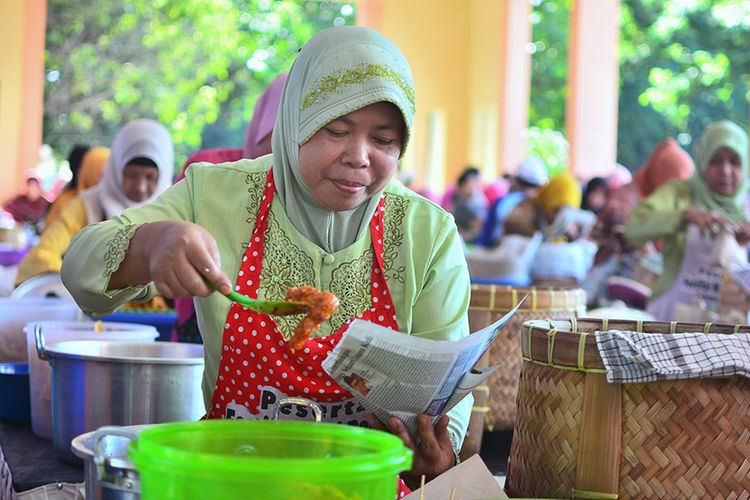 Salah seorang pedagang saat menyajikan sego boranan kepada konsumen.