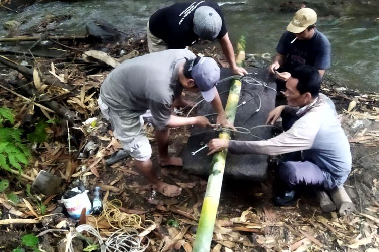 Petugas dari BPCB Jawa Timur memindahkan batu andesit yang diduga berfungsi sebagai meja altar dari aliran sungai di Desa Kemloko, Kecamatan Nglegok, Kabupaten Blitar, Kamis (19/5/2022)