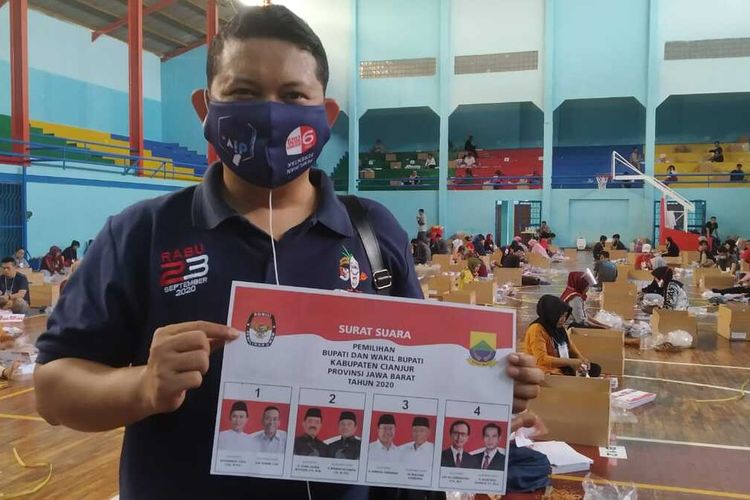 Komisioner KPU Cianjur Hilman Wahyudi memerlihatkan surat suara untuk Pilkada Cianjur 2020 yang kondisinya rusak saat kegiatan sortir lipat di Gelanggang Pemuda Cianjur, Senin (16/11/2020).