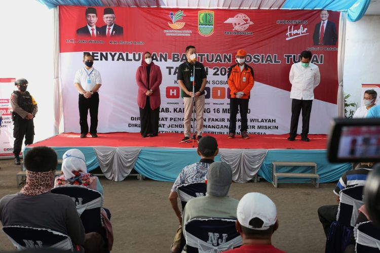 Menteri Sosial Juliari P Batubara memberikan sambutan saat distribusikan Bansos Sosial Tunai  di Kantor Pos Cikampek, Kabupaten Karawang  (16/05/2020), tampak sebelah kanan Mensos, Dirut PT Pos Gilarsi Wahyu Setijono (topi dan jaket oranye).